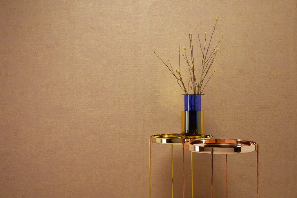 Monochrome Tapete in warmem Goldton mit feiner Struktur und Design-Beistelltisch – THE NEW BOMBAY design edition