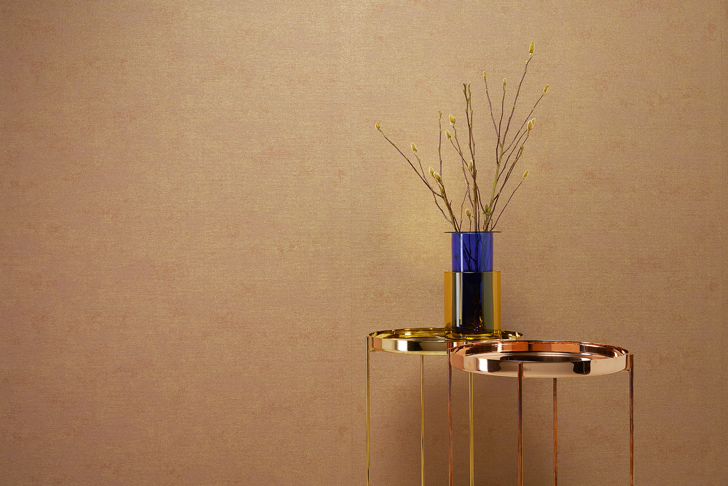 Monochrome Tapete in warmem Goldton mit feiner Struktur und Design-Beistelltisch – THE NEW BOMBAY design edition