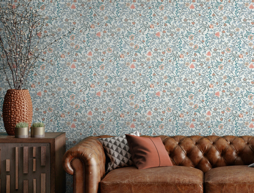 Florale HERITAGE Tapete im Arts-&-Crafts-Stil hinter braunem Ledersofa und dekorativer Vase mit Zweigen